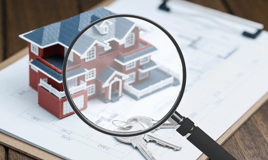 magnifying glass showing a house on a form and keys