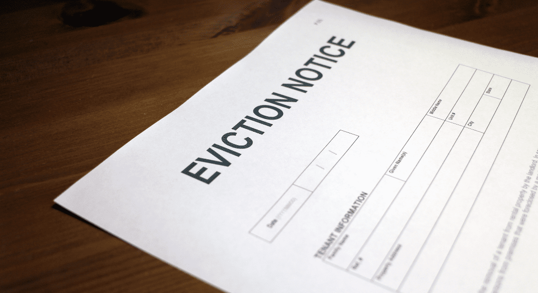 A close-up of a paper document titled "Eviction Notice" laying on a wooden surface, with blank fields for tenant information.