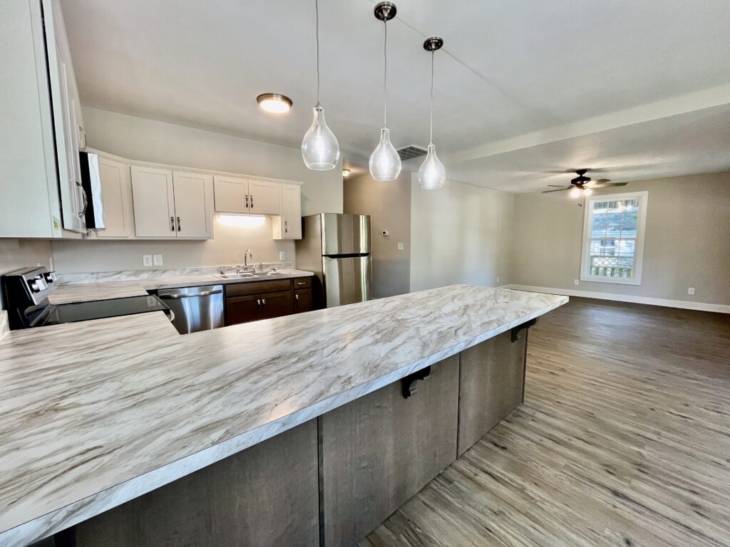 kitchen with fridge, microwave oven, cooking range and white cabinets